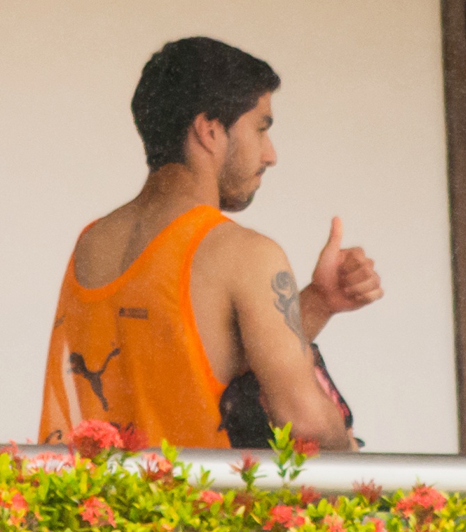 Uruguay's Luis Suarez gives a thumbs-up from a balcony of the team's hotel in Natal