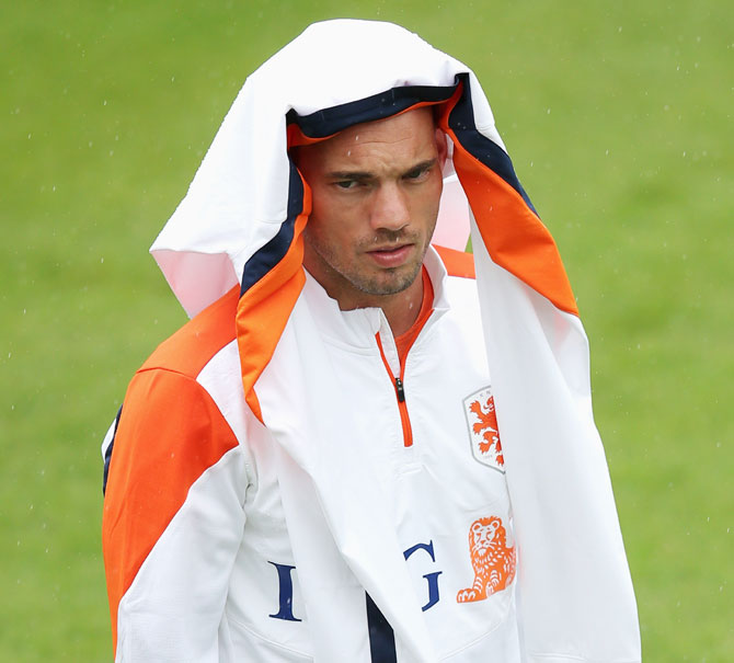 Wesley Sneijder shelters from the rain during the Netherlands training session