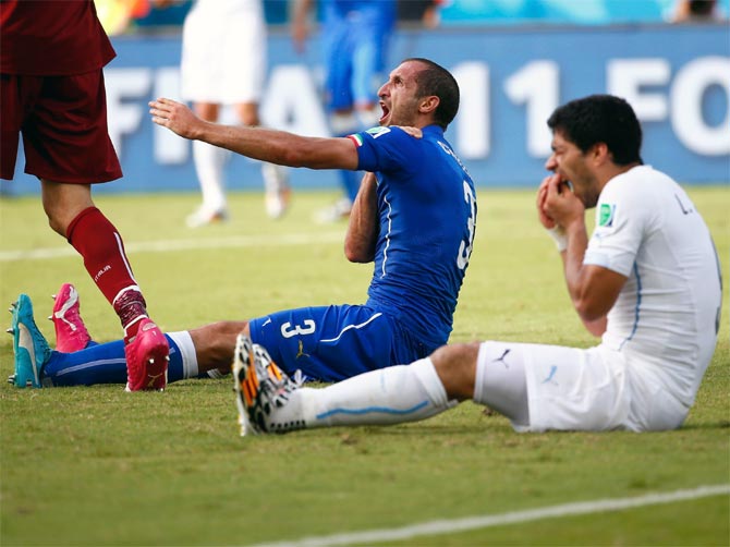 Uruguay's Luis Suarez (right) reacts after biting Italy's Giorgio Chiellini