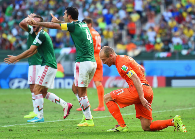 Arjen Robben of the Netherlands and Rafael Marquez of Mexico react the referee awarded the penalty to The Netherlands during their World Cup last 16 match on Sunday