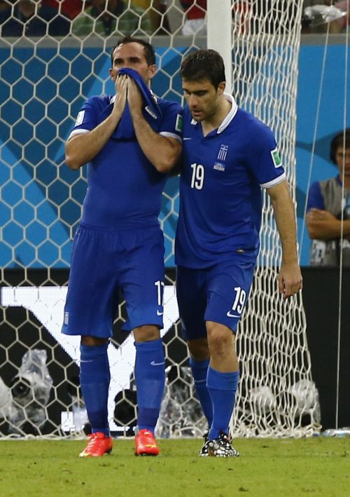 Greece's Theofanis Gekas, left, reacts after missing his penalty kick as team mate Sokratis Papastathopoulos consoles him