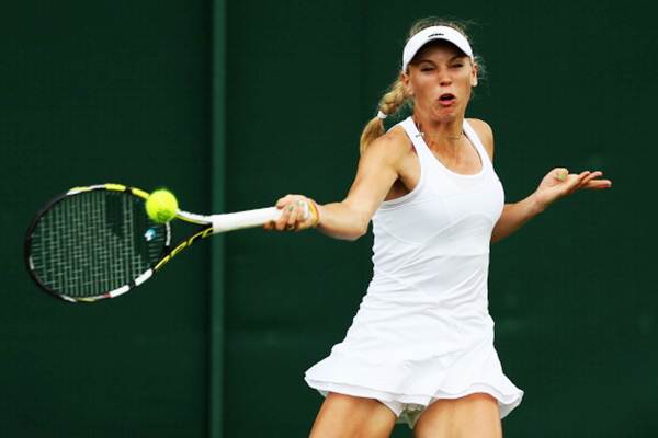 Caroline Wozniacki of Denmark plays a forehand during her first round match against Shahar Peer of Israel