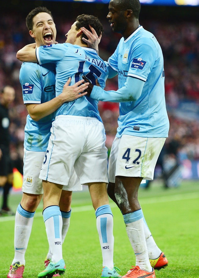 Samir Nasri, left, Yaya Toure, right, celebrate with goalscorer Jesus Navas of Manchester City.
