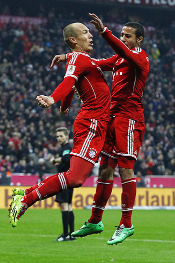Bayern Munich's Arjen Robben (L) and Thiago jump in the air while celebrating a goal during their German Bundesliga match against Schalke 04 in Munich on Saturday