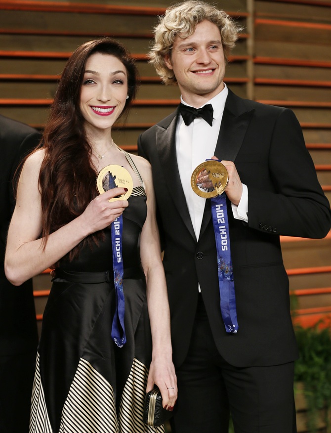 Ice dancers Meryl Davis and Charlie White, right, hold up their gold medals.