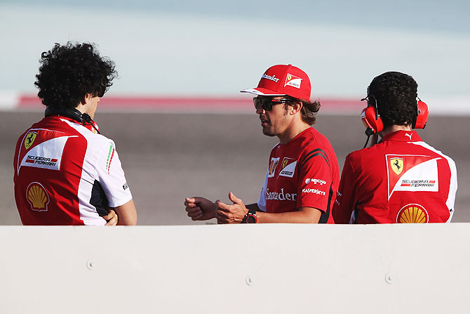 Fernando Alonso (centre) of Spain and Ferrari