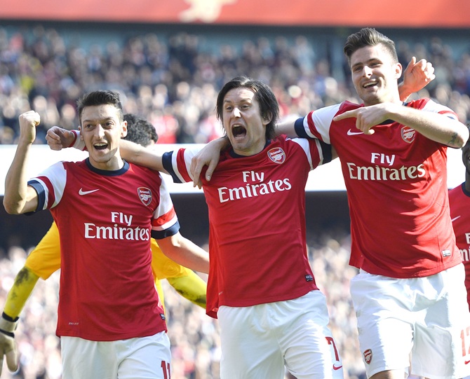 From left, Arsenal's Mesut Ozil, Tomas Rosicky and Olivier Giroud celebrate.