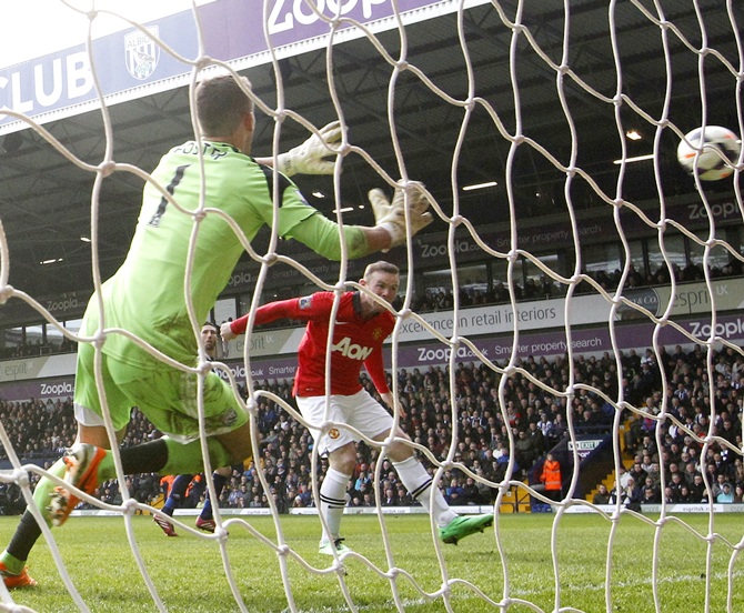 Manchester United's Wayne Rooney,right, scores a goal during their English Premier League match against West Bromwich Albion.
