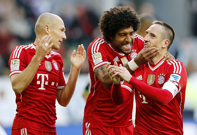 Bayern's Franck Ribery of France (right) celebrates with teammates Arjen Robben (left) and Dante after scoring against Wolfsburg during their German Bundesliga match in Wolfsburg, on Saturday