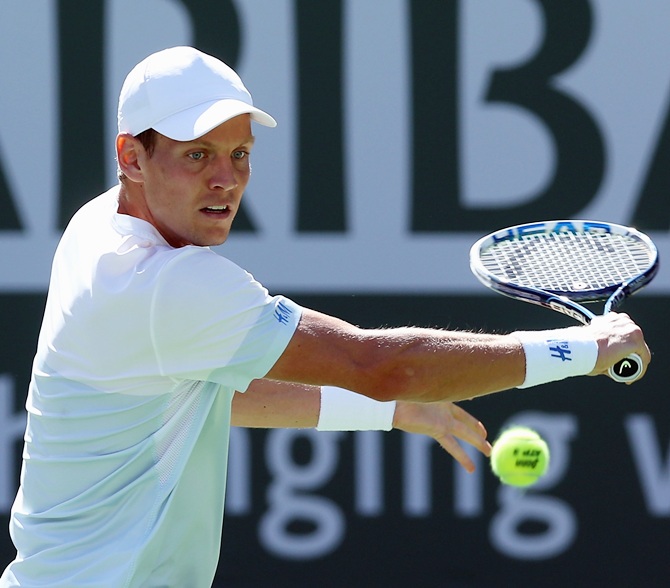Tomas Berdych of the Czech Republic returns a backhand to Roberto Bautista Agut of Spain