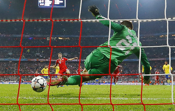 Arsenal's Lukasz Fabianski saves a penalty shot by Bayern Munich's Thomas Mueller (left) on Tuesday