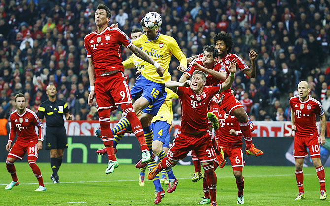 Bayern Munich's Mario Mandzukic (2nd from left ) is beaten by Arsenal's Olivier Giroud (12) in an aerial challenge