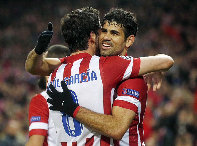 Atletico Madrid's Raul Garcia and teammate Diego Costa (right) celebrate after beating AC Milan in their Champions League last 16 second leg match at Vicente Calderon stadium in Madrid on Tuesday