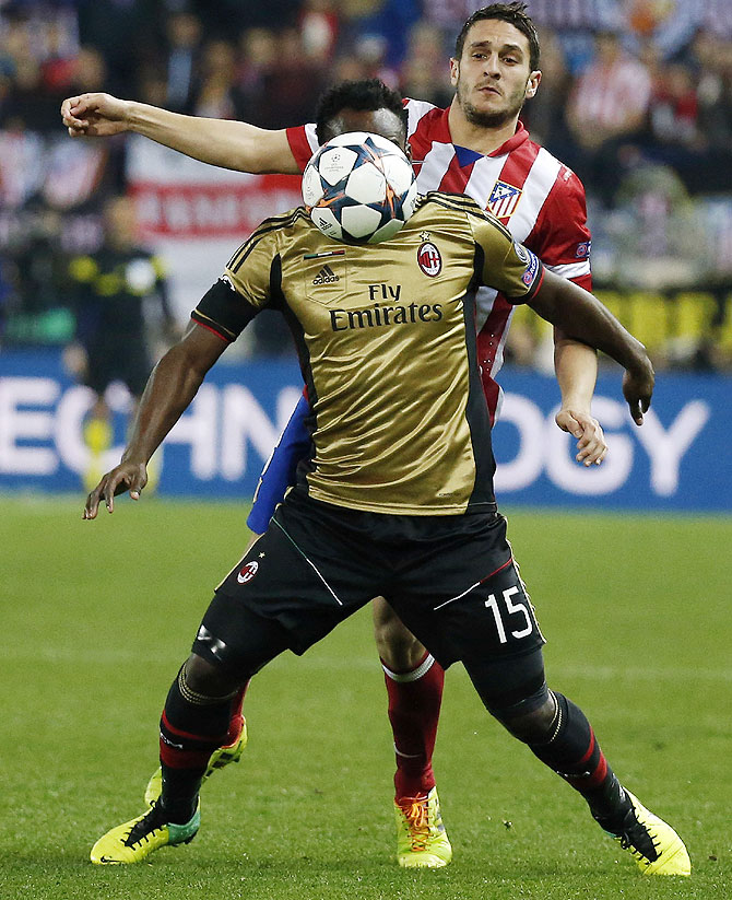 Atletico Madrid's Koke (back) and AC Milan's Michael Essien vie for possession on Tuesday