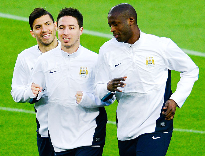Manchester City FC players Sergio Aguero (left), Samir Nasri (centre) and Yaya Toure warm up during a training session on Tuesday