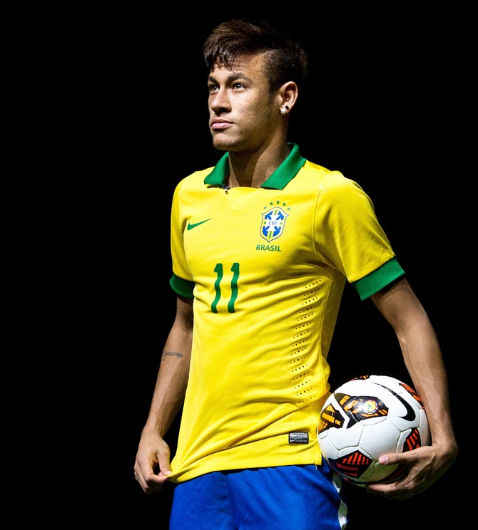 Neymar poses with Brazil's new jersey for the 2014 FIFA World Cup