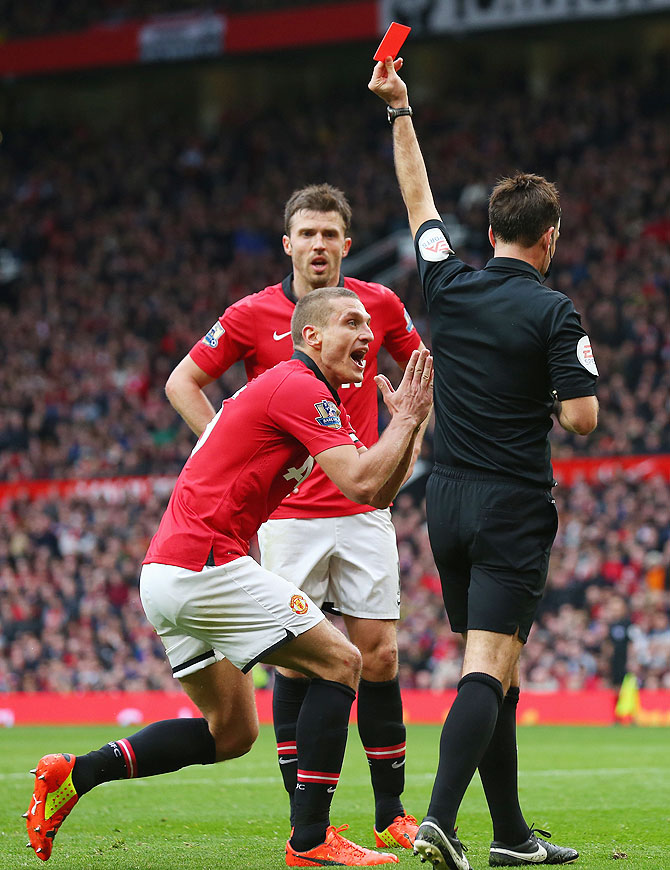 Nemanja Vidic of Manchester United is shown a red card by referee Mark Clattenburg for fouling Liverpool's Daniel Sturridge on Sunday