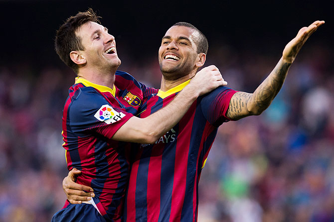 FC Barcelona's Lionel Messi celebrates with teammate Daniel Alves after scoring against Osasuna during their La Liga match on Sunday