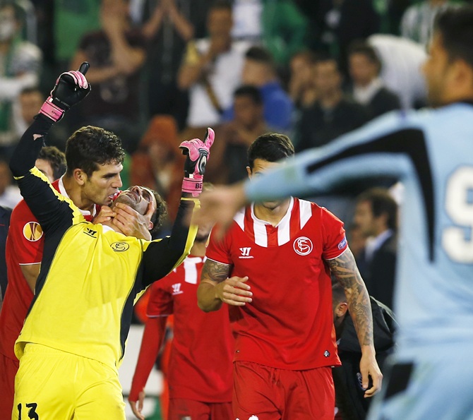 Sevilla's goalkeeper Antonio Alberto Bastos 'Beto', second left, celebrates with Federico Fazio after winning their Europa League soccer match against Real Betis