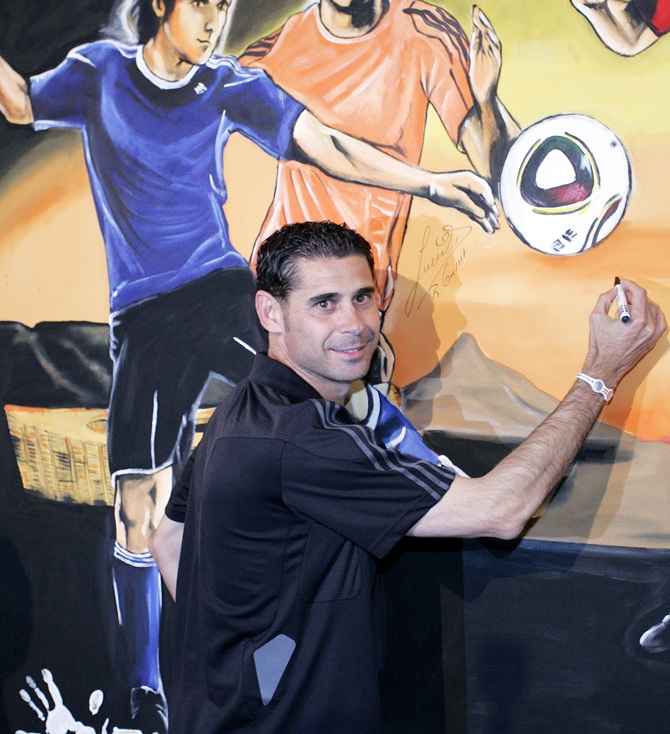 Fernando Hierro signs a painting during a media event
