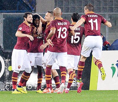 Gervinho of AS Roma is mobbed by teammates after scoring his team's opening goal against AC Chievo Verona during their Serie A match on Saturday