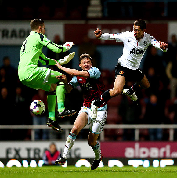 West Ham's goalkeeper Adrian and defender George McCartney compete for the ball against Manchester United's Javier Hernandez on Saturday
