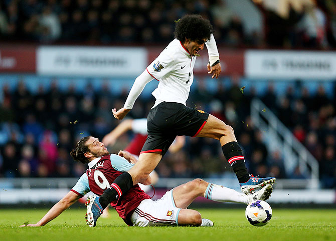 Marouane Fellaini of Manchester United is tackled by Andy Carroll of West Ham during their match on Saturday