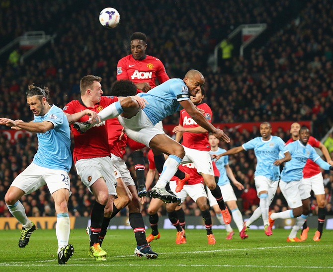 Vincent Kompany of Manchester City tangles with Phil Jones and Danny Welbeck of Manchester United