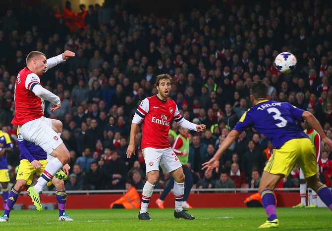 Lukas Podolski of Arsenal scores their first goal