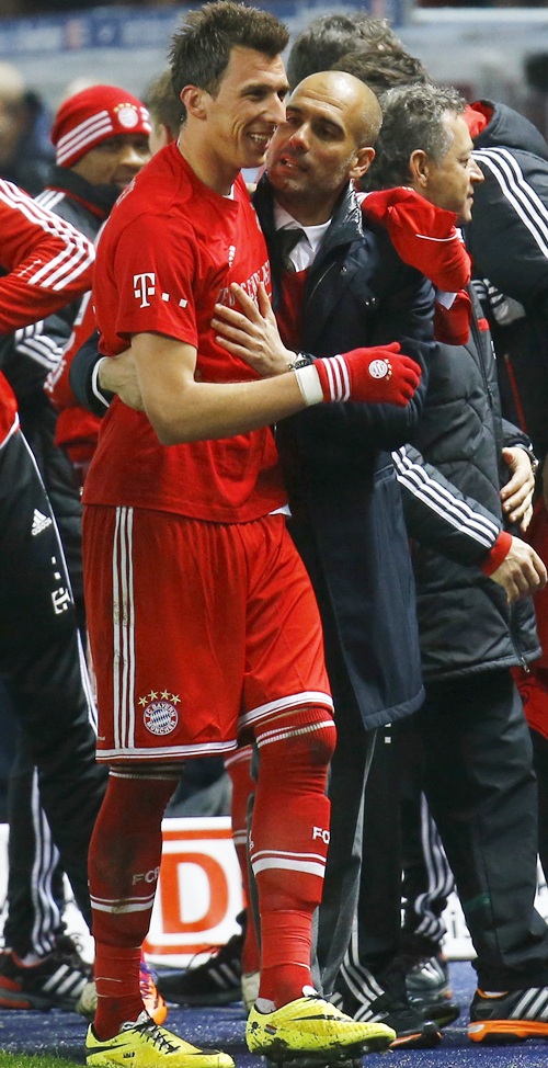Bayern Munich's coach Pep Guardiola speaks with Mario Mandzukic,left, as they celebrate