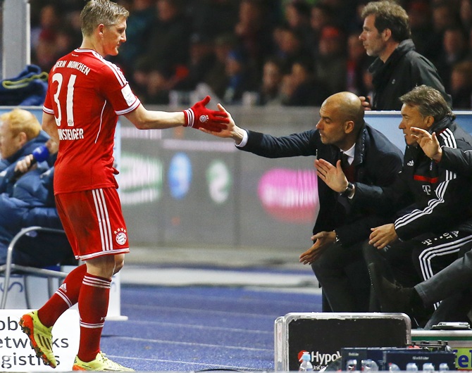 Bayern Munich's Bastian Schweinsteiger, left, claps hands with coach Pep Guardiola