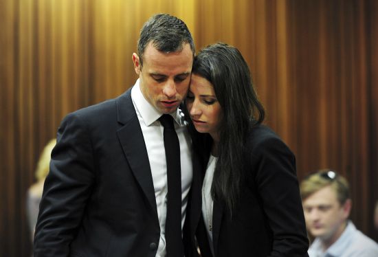 Olympic and Paralympic track star Oscar Pistorius stands beside his sister Aimee during court proceedings