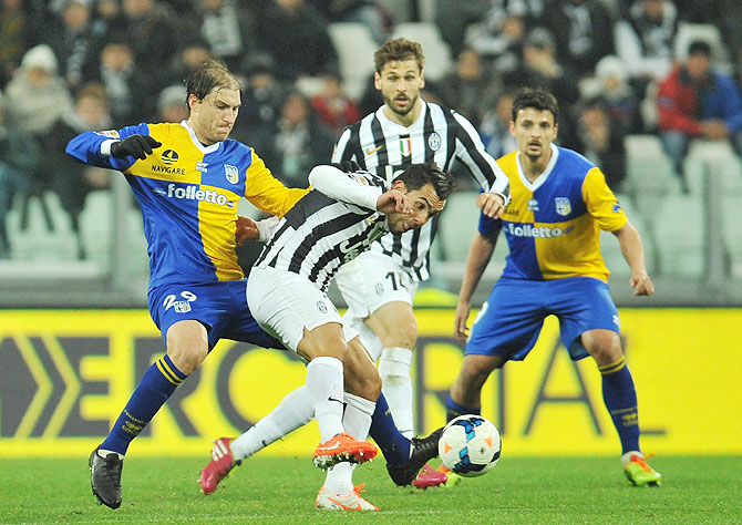 Carlos Tevez (right) of Juventus is tackled by Gabriel Alejandro Paletta of Parma FC during the serie A match at Juventus Arena in Turin, Italy on Wednesday