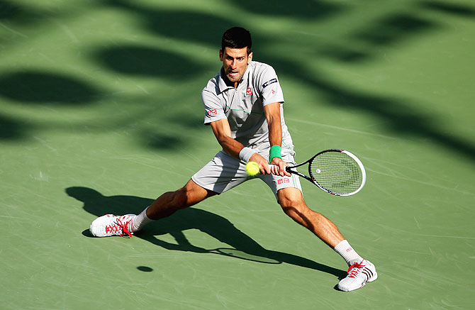 Novak Djokovic of Serbia stretches to play a backhand against Andy Murray of Great Britain during their quarter-final on Wednesday