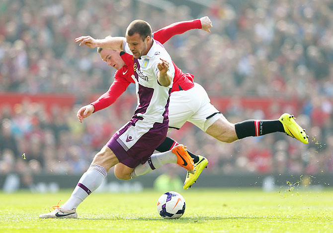 Wayne Rooney of Manchester United tangles with Ron Vlaar of Aston Villa during their English Premier League match on Saturday