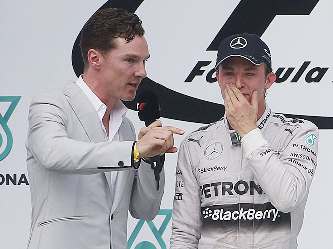 British actor Benedict Cumberbatch interviews second-placed Mercedes Formula One driver Nico Rosberg of Germany on the podium after the Malaysian F1 Grand Prix at Sepang International Circuit on Sunday