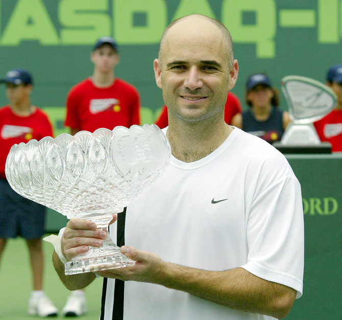 Andre Agassi poses for photographers with the winner's trophy in Miami