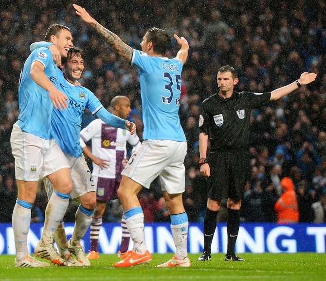 Edin Dzeko,left, of Manchester City celebrates scoring his team's second goal