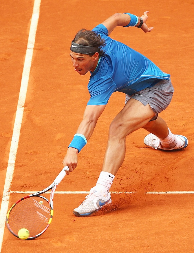 Rafael Nadal stretches to play a backhand volley against Juan Monaco