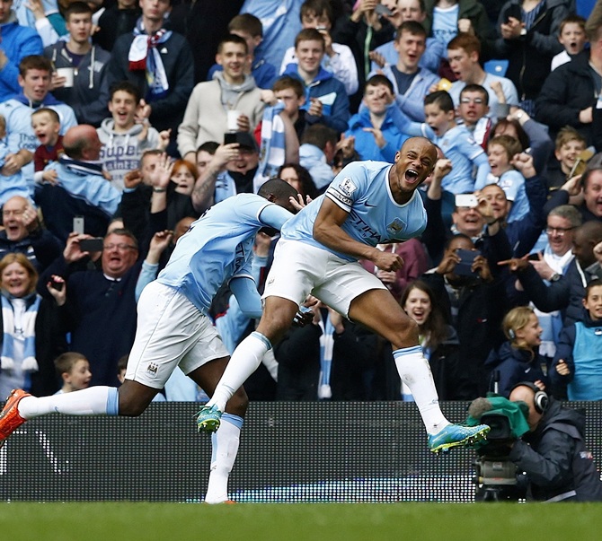 Manchester City's captain Vincent Kompany,right, celebrates after scoring against West Ham United