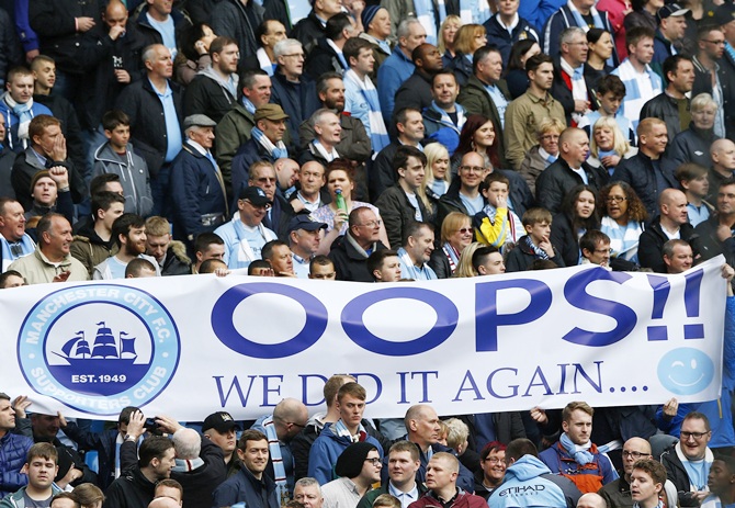 Manchester City fans hold a banner as their team take on West Ham United