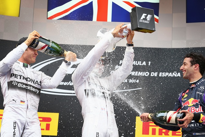 Nico Rosberg,left, of Germany and Mercedes GP and Daniel Ricciardo of   Australia and Infiniti Red Bull Racing spray champagne over race winner Lewis Hamilton of Great Britain and Mercedes GP