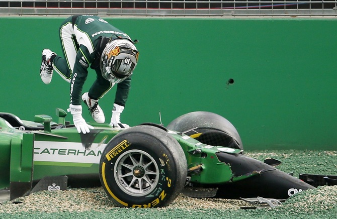 Caterham Formula One driver Kamui Kobayashi of Japan gets out of his car after colliding