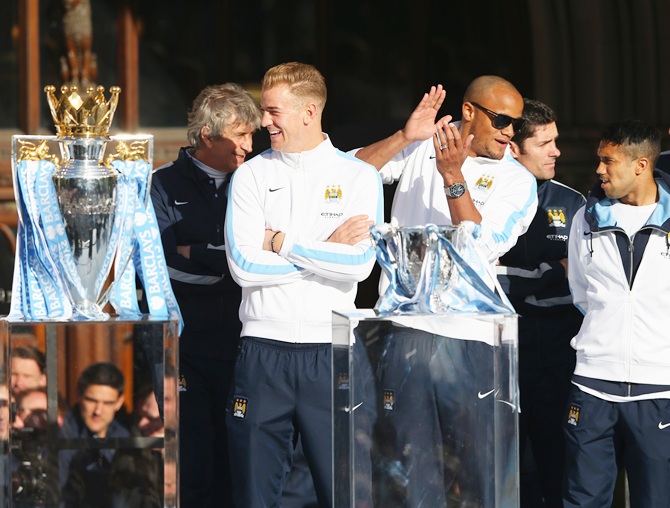 Vincent Kompany, Gael Clichy and Joe Hart of Manchester City look on outside   Manchester Town Hall at the start of the Manchester City victory parade