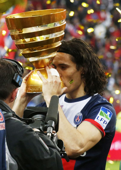 Paris St Germain's Edinson Cavani kisses the trophy after defeating   Olympique Lyon in the French League Cup final at the Stade de France stadium in Saint-Denis