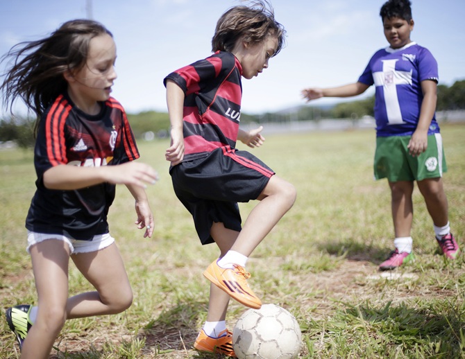 Children play a Sunday 'pelada' soccer match in front of the Mane Garrincha Stadium in Brasilia, a World Cup host city