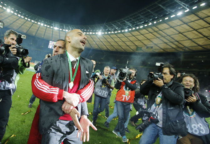 Bayern Munich's coach Pep Guardiola is carried by Franck Ribery as they celebrate winning their German Cup