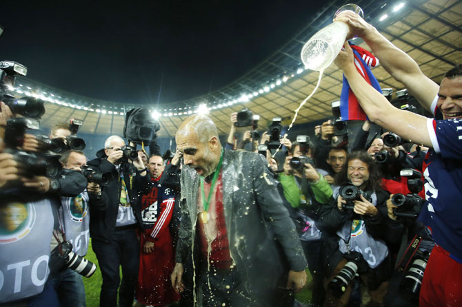 Bayern Munich's Claudio Pizarro (right) showers with beer coach Pep Guardiola after their German Cup