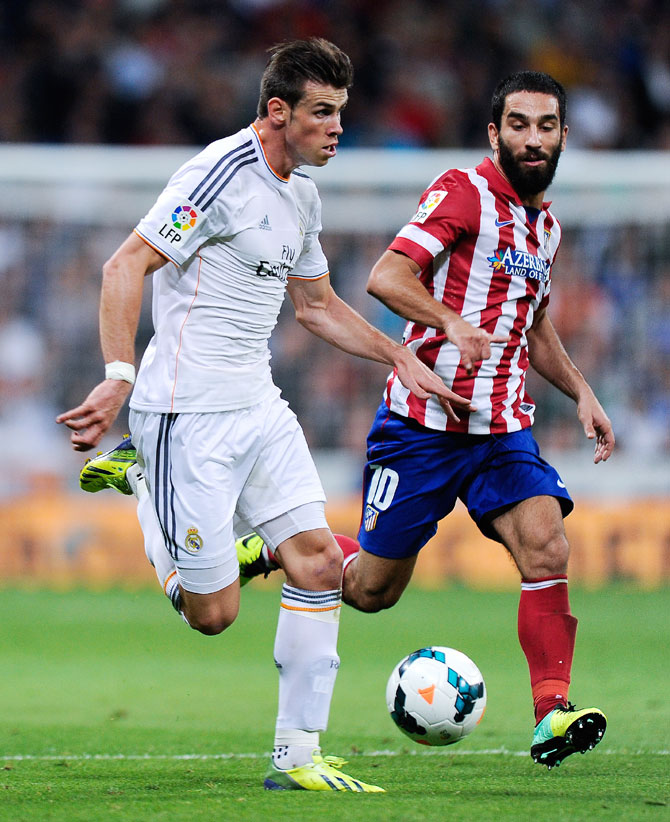 Gareth Bale of Real Madrid duels for the ball with Arda Turan of Atletico de Madrid 