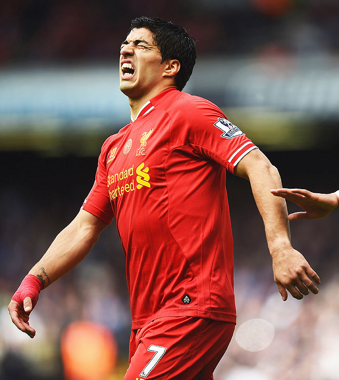 Liverpool's Luis Suarez winces in pain after suffering a knee injury during an English Premier League match on May 11